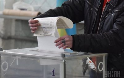Чоловік вкидає бюлетень в урну для голосування. Фото: УНІАН